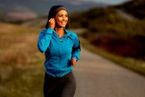 Uśmiechnięta kobieta biega aby zadbać o zdrowie i obniżyć cholesterol